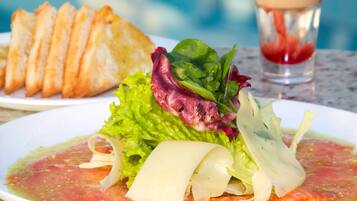 Um prato de comida com salada, uma fatia de pão e um copo de água.
