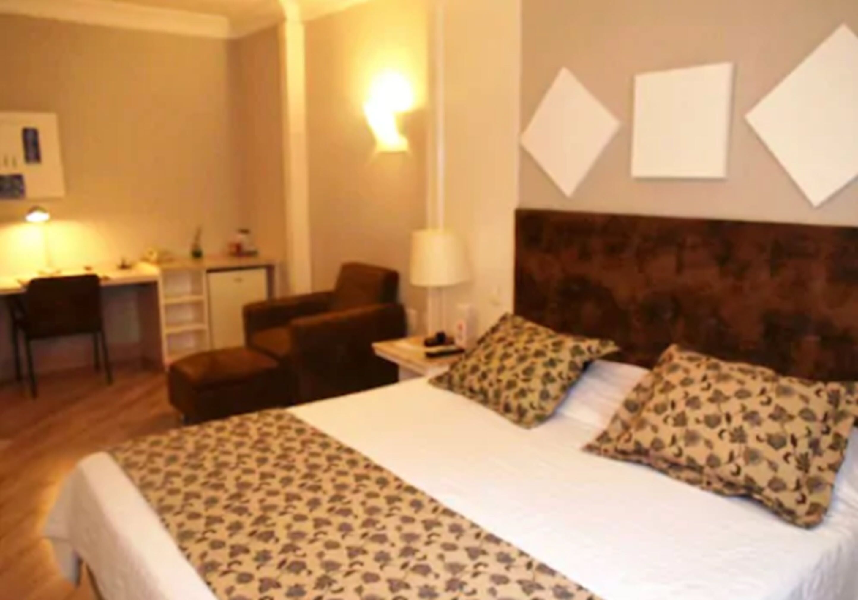 Una habitación de hotel con una cama grande, un escritorio y una silla.