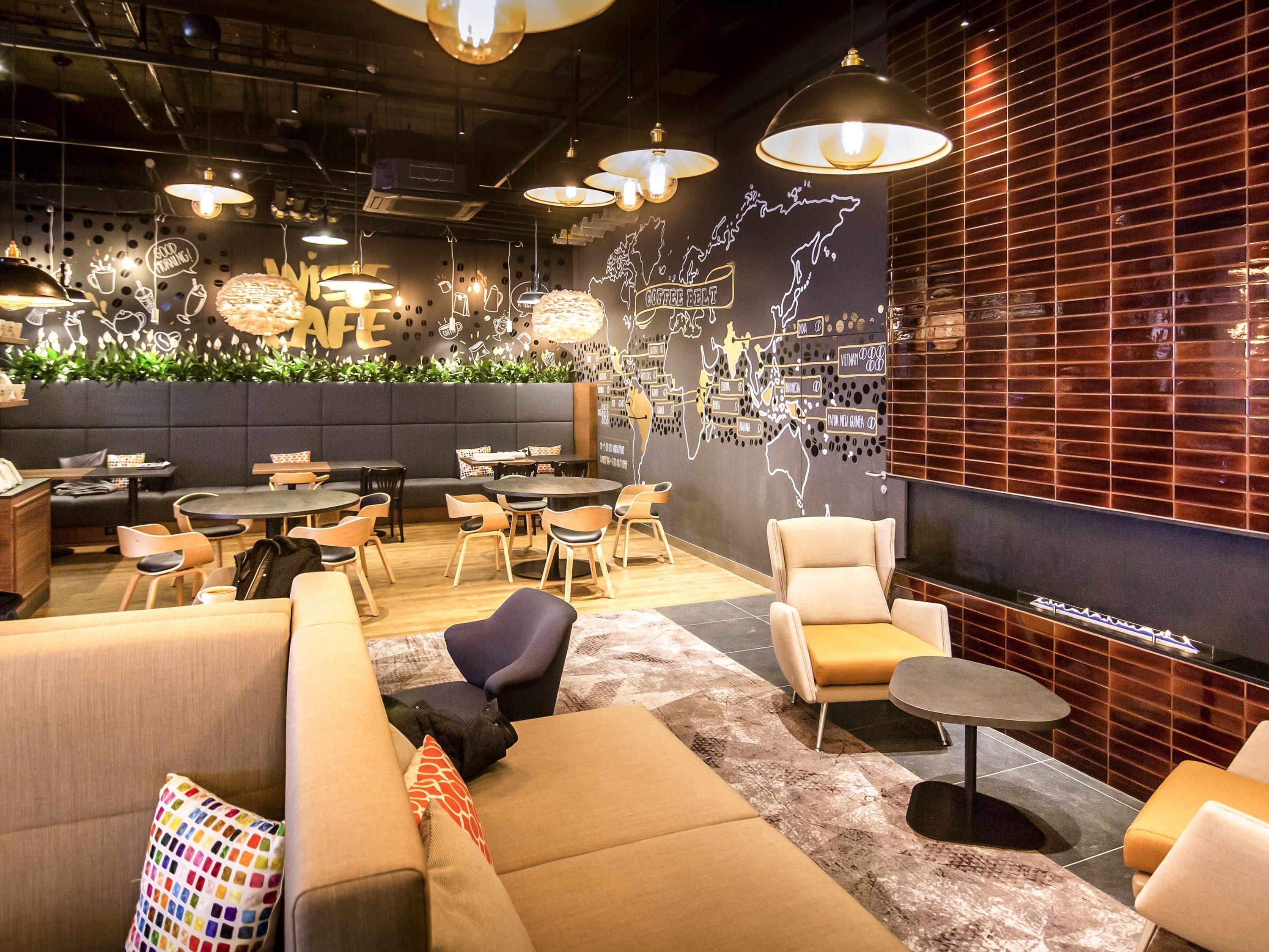 A modern lounge area with seating arrangements, tables, and decorative wall art.