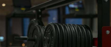 A weightlifting bench with adjustable weights and a flat bench.
