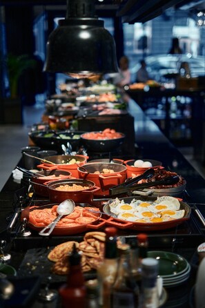 A buffet with various dishes and condiments.