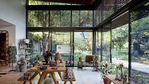 A spacious room with a large window, a wooden table, and various decorative items.