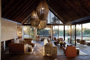 Un vaste espace intérieur doté d’un haut plafond, de grandes fenêtres et de différents types de sièges.
