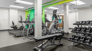 A gym with treadmills, elliptical machines, and a bench press. - Holiday Inn Cleveland by IHG (Cleveland)
