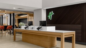 A reception desk with a modern design, featuring a wooden table and a black counter. - Holiday Inn Cleveland by IHG (Cleveland)