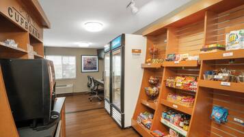A kitchenette area with a refrigerator, microwave, and coffee machine.