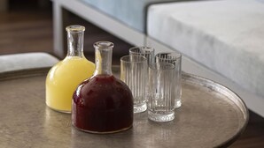 A round metal table with two glass bottles and four glasses. - Armada Istanbul Old City Hotel (Istanbul)