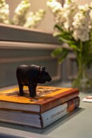 Ein Stapel Bücher mit einer kleinen Figur obenauf.