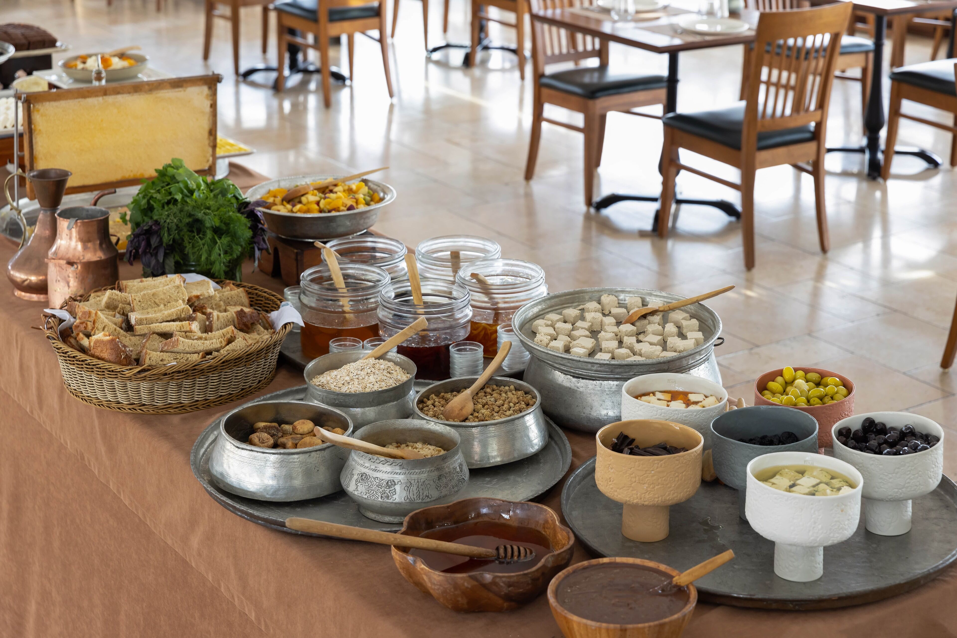 A buffet table with various food items and utensils.