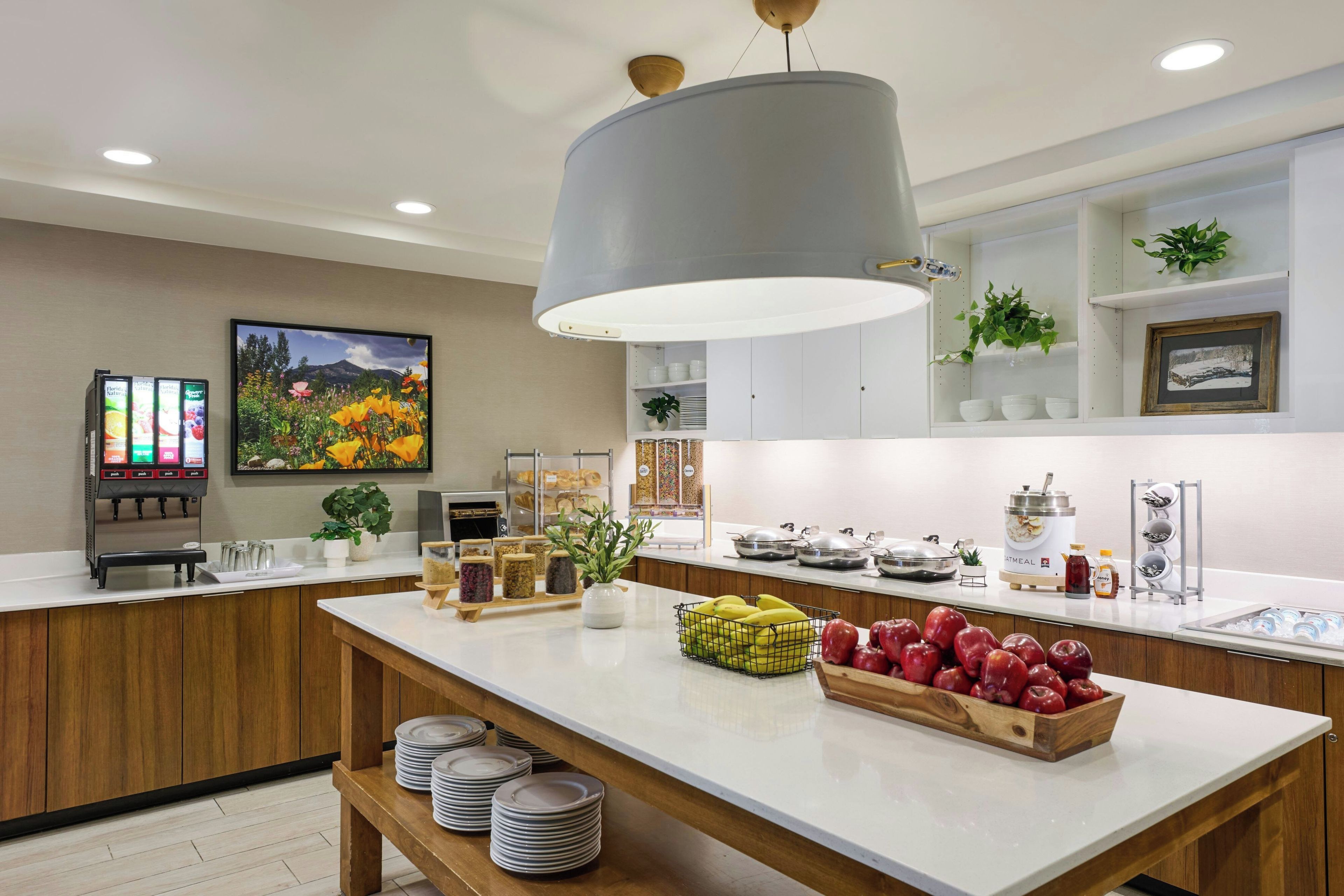 Cocina moderna con una isla central, cafetera y diversos alimentos.