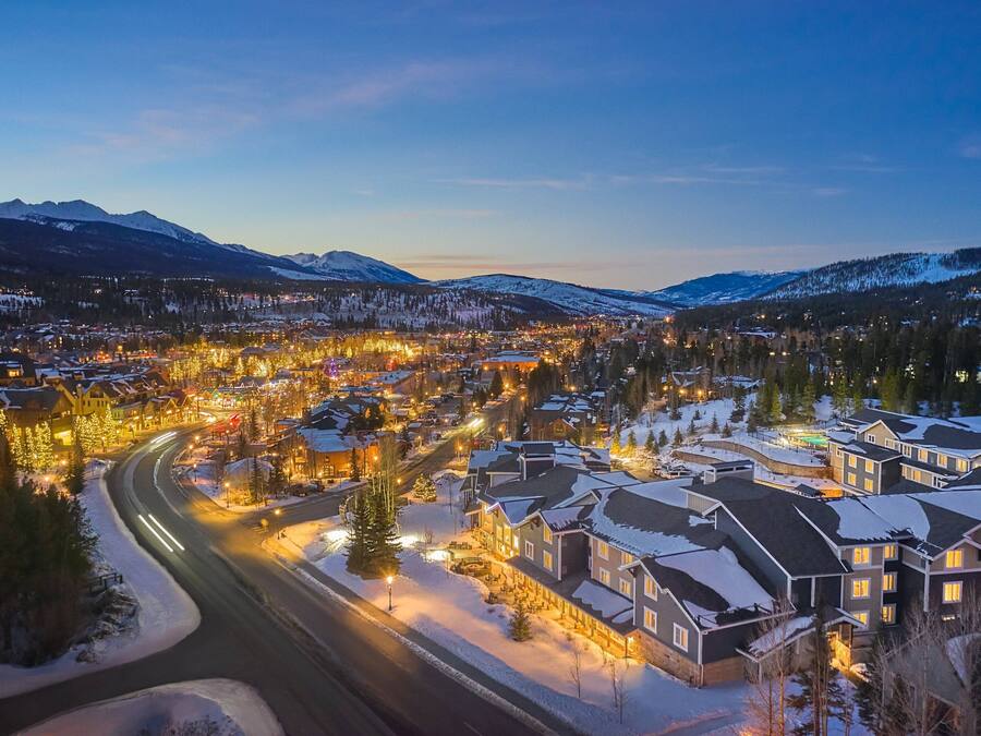 A snow-covered residential area with houses and a winding road.