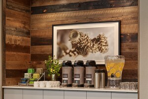 Una estación de café con varias cafeteras, dispensador de agua y diferentes recipientes para café.