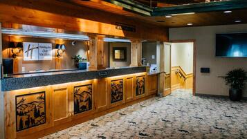 A reception area with a wooden counter, a sign for 'Holiday Inn Club Vacations,' and a TV mounted on the wall.