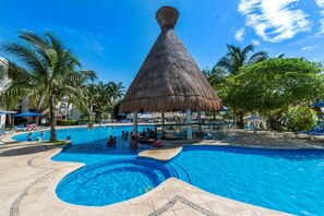 Alberca al aire libre, sombrillas en la alberca y camastros 