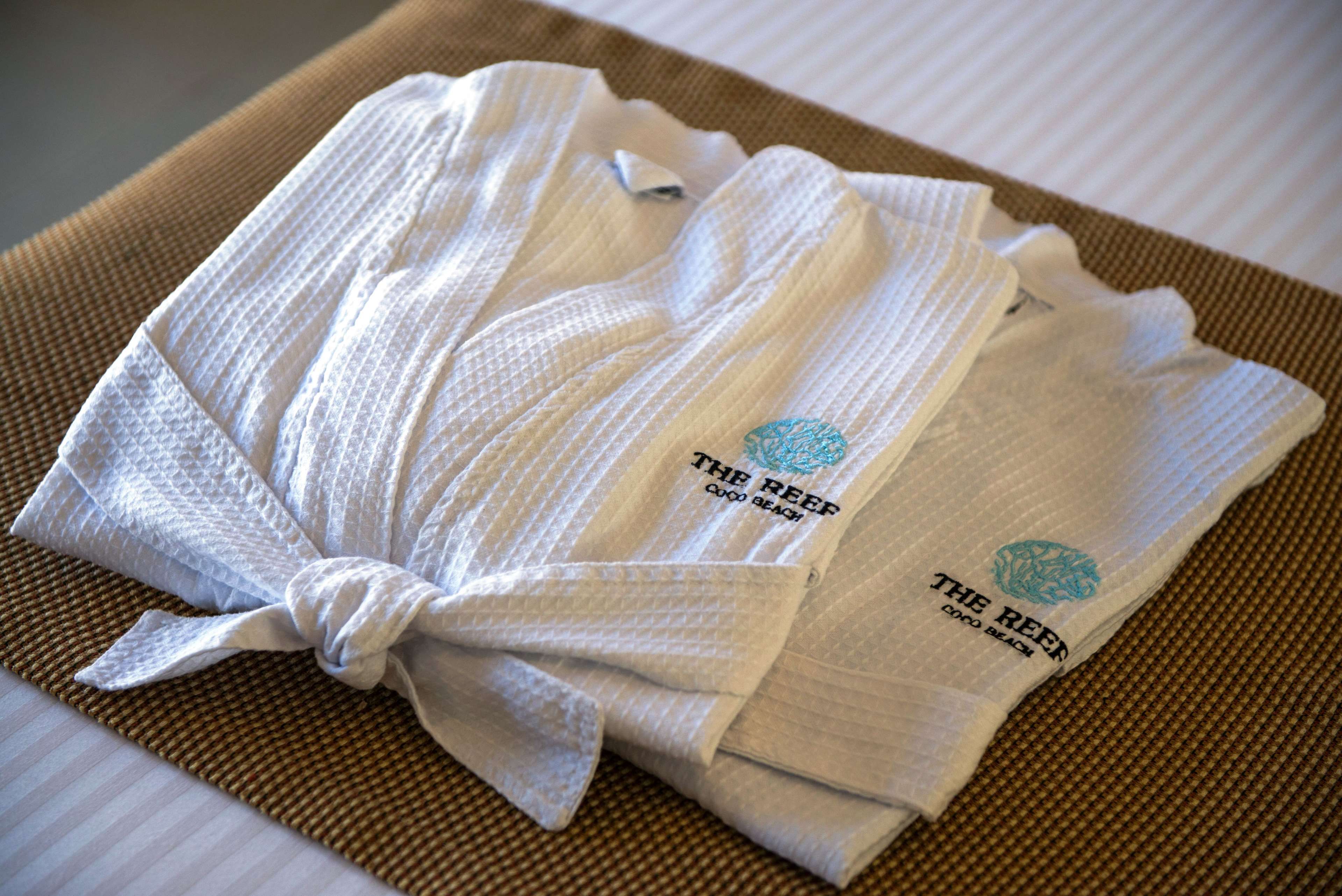 A neatly folded towel with a logo and text on it, placed on a textured mat.