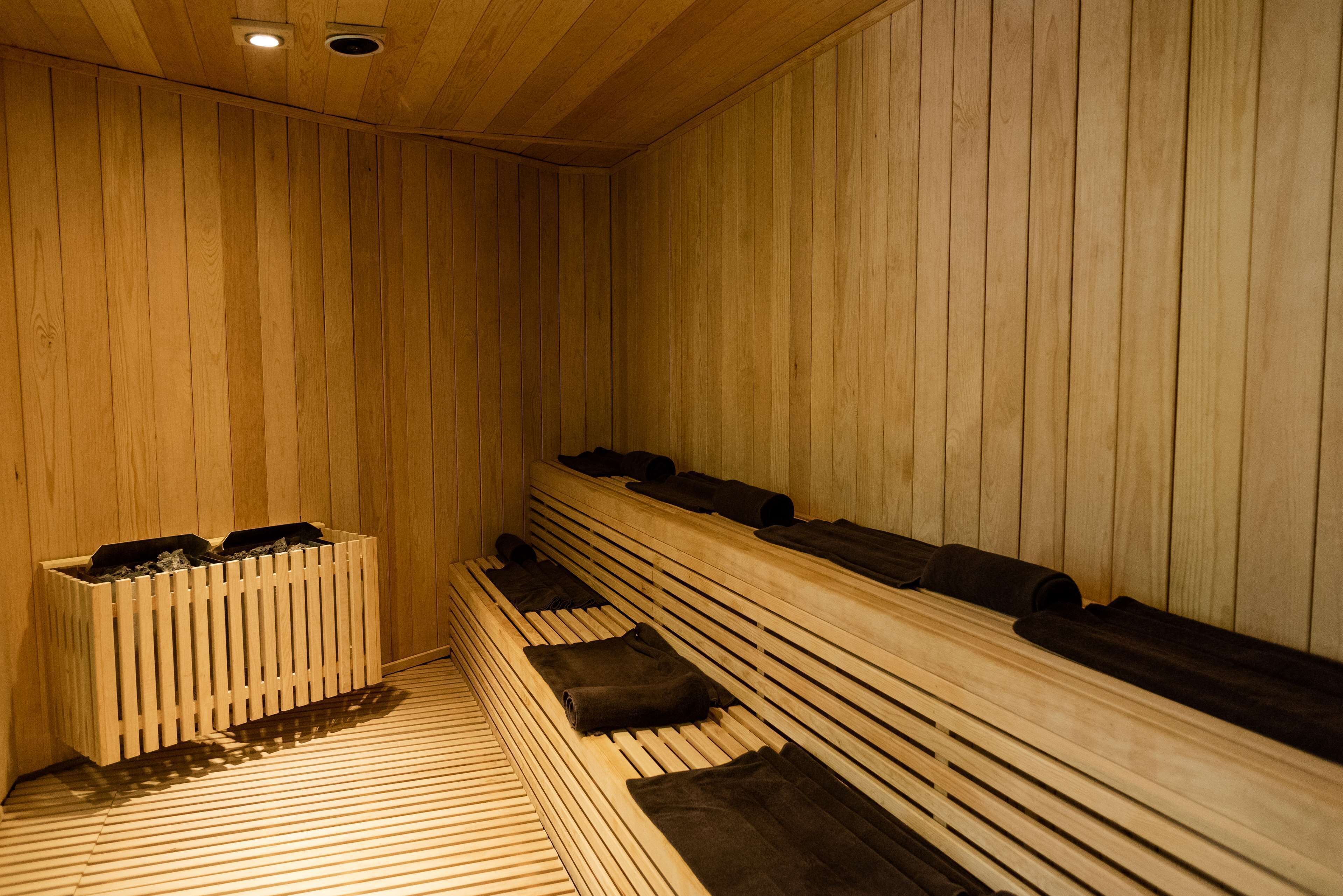 A sauna with wooden benches and benches, a wooden floor, and a ventilation system.