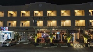 A multi-story building with the sign "TRAVEL INN" indicating it is a hotel. There are several windows on each floor, and the entrance is visible with a gated area and potted plants. - Travel Inn Hotel (Simpson Bay)