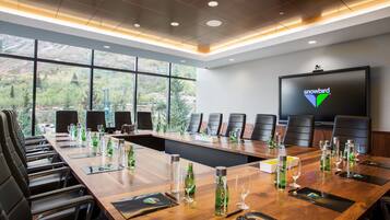 A conference room with a long table, chairs, and a large screen displaying the 'snowbird' logo.