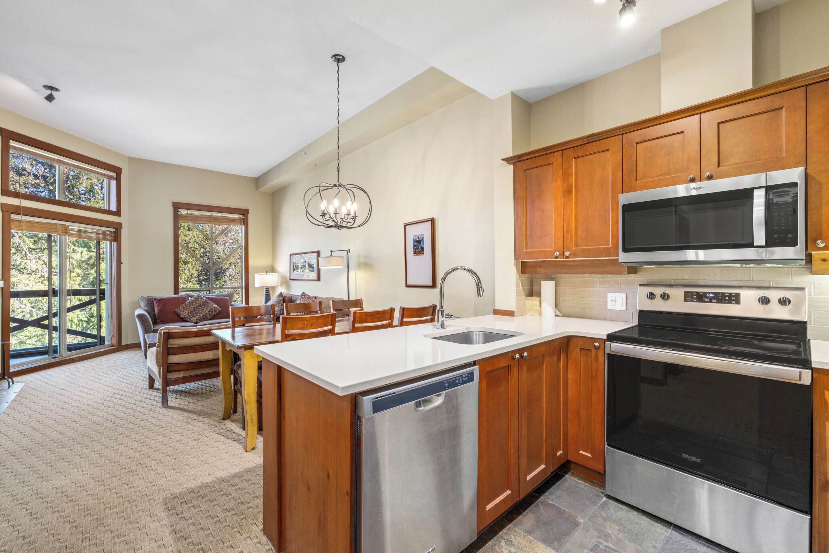 A modern kitchen with wooden cabinets, stainless steel appliances, and a large island.