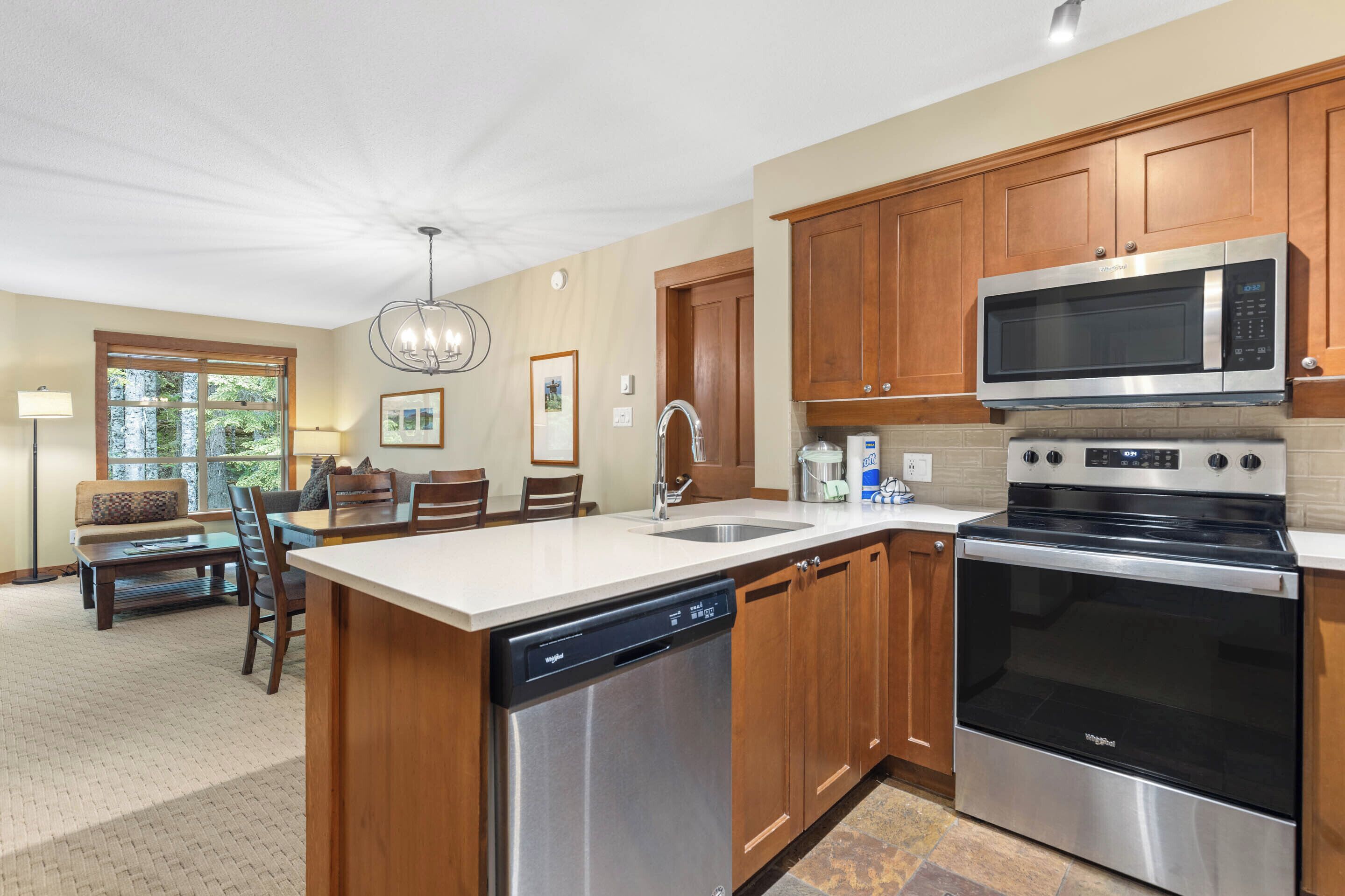 A modern kitchen with wooden cabinets, stainless steel appliances, and a dishwasher.