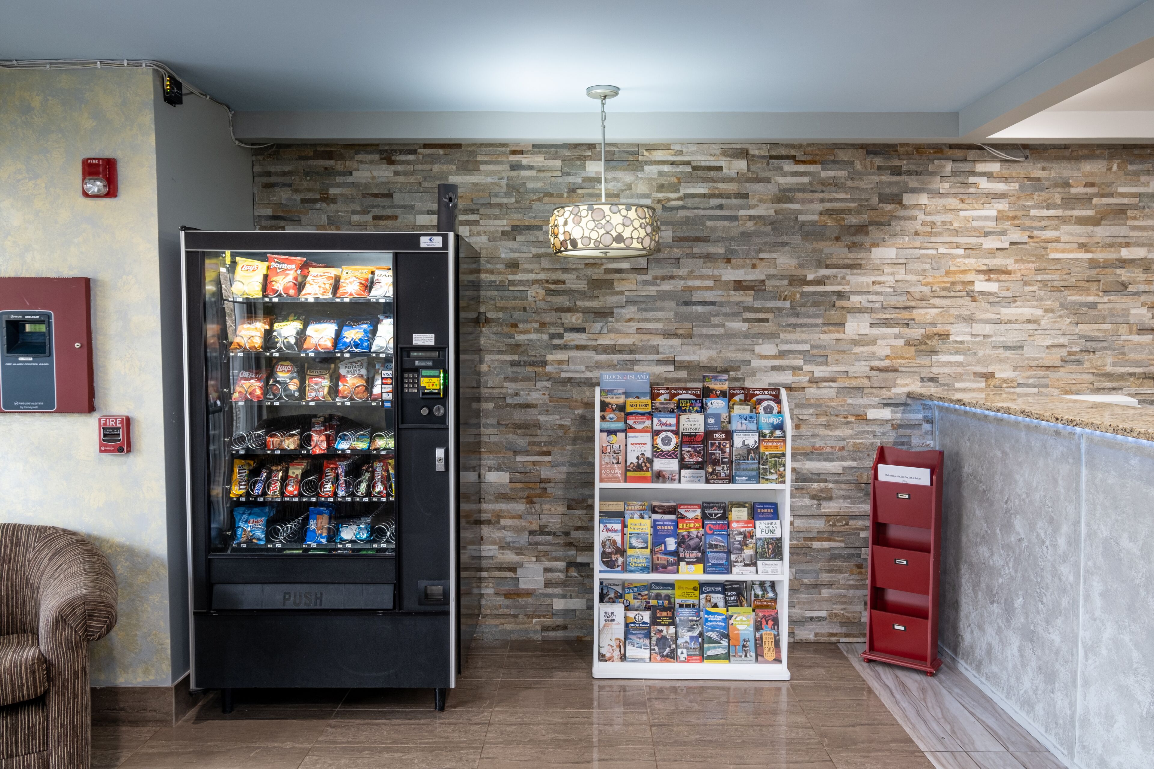 A vending machine with snacks and a book display in a lobby area.