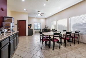 Un comedor con una mesa y sillas, una kitchenette y una despensa.