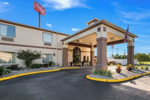 A Red Roof Inn with a covered entrance, a clear sky, and a flag. - Red Roof Inn Carrollton (Carrollton)