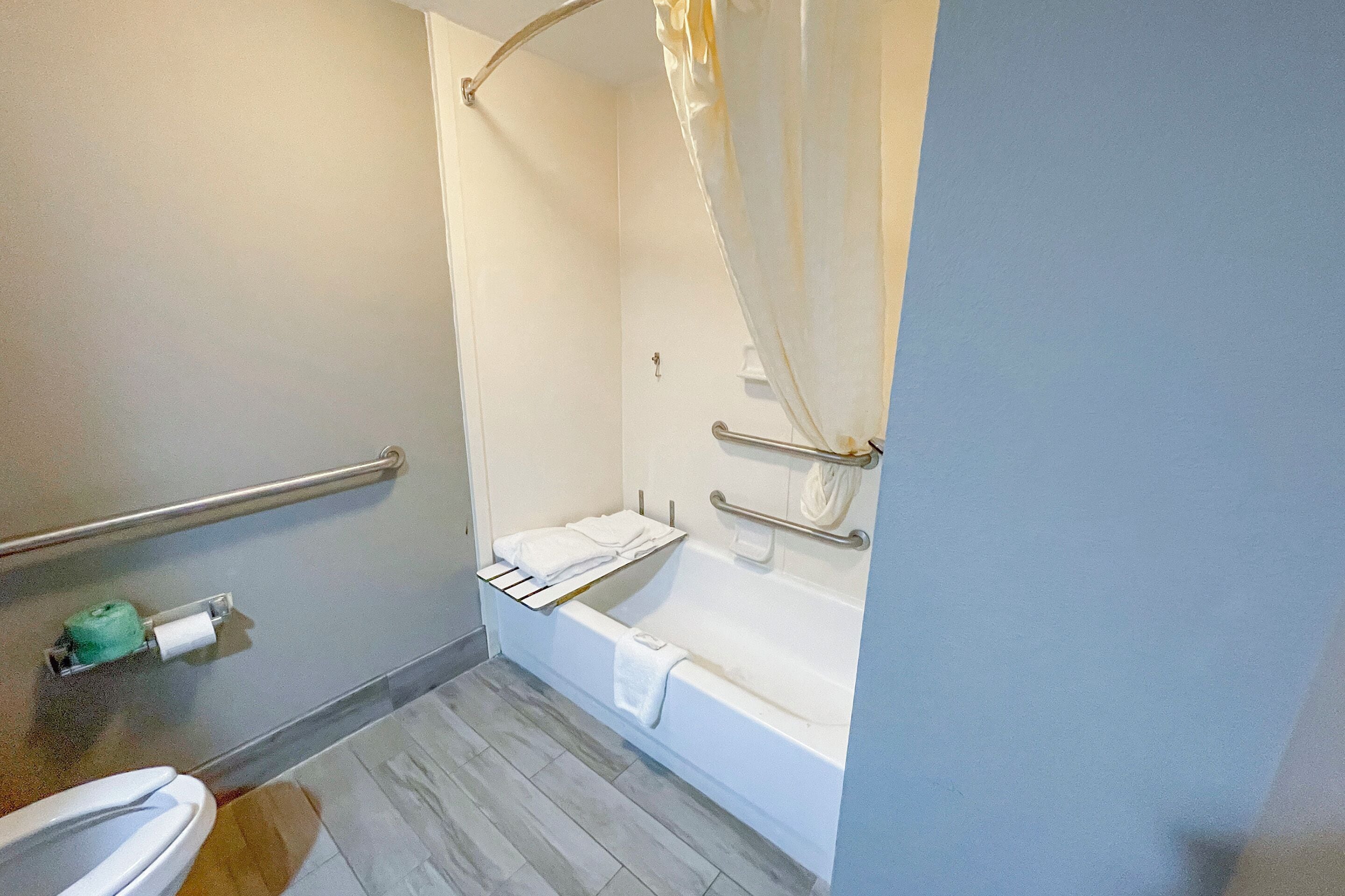 A bathroom with a toilet, a shower with a glass door, and a bathtub.