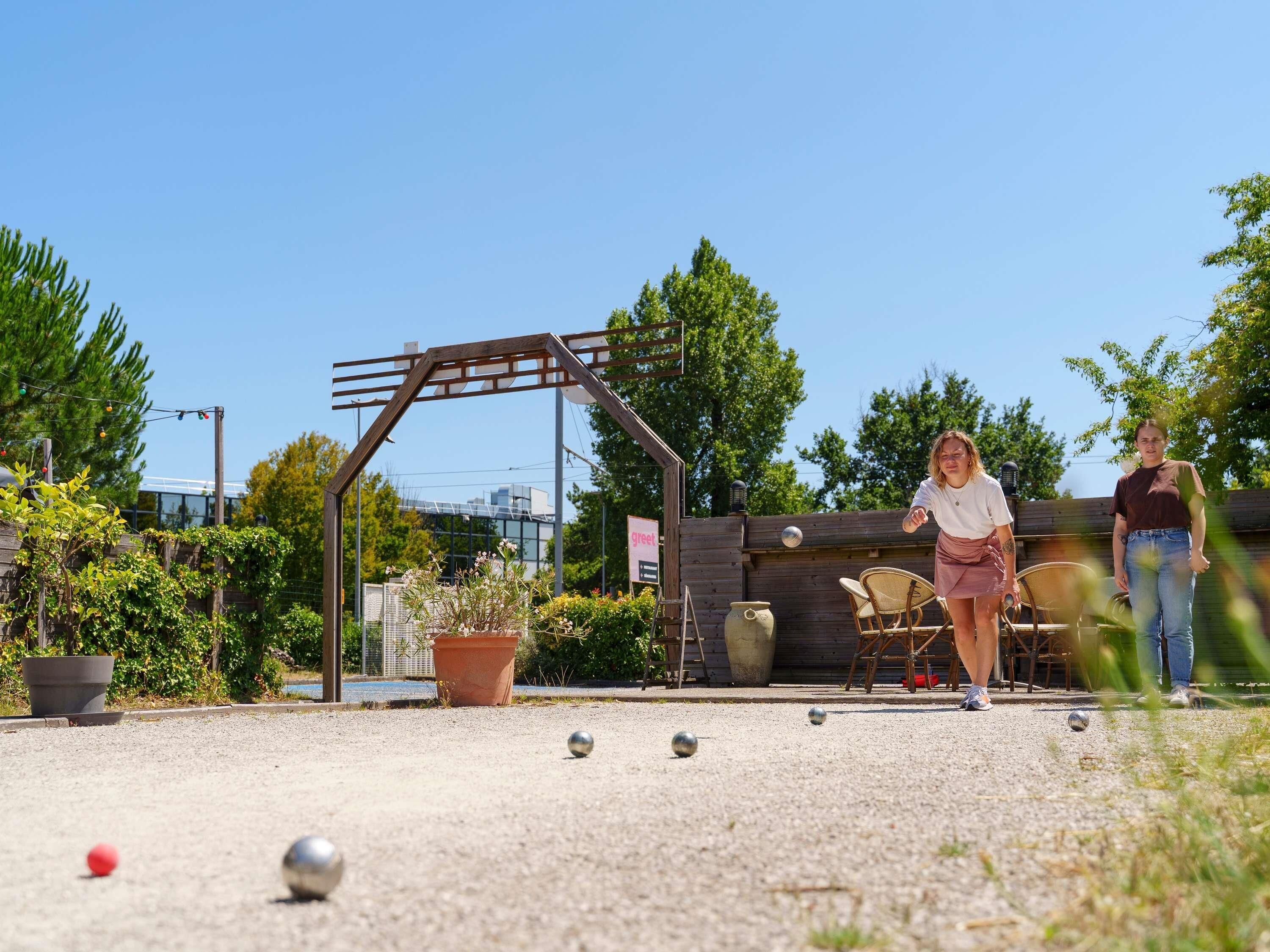 An outdoor area with a pergola, potted plants, and a seating arrangement.