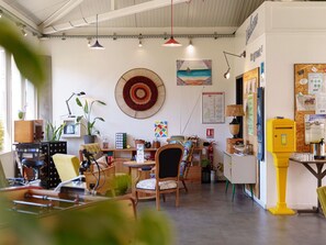 A room with a wooden table, chairs, a map on the wall, and a yellow fire alarm. - greet Hotel Bordeaux Aeroport (Merignac)