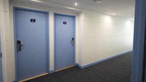 Un pasillo con dos puertas azules, cada una con un número.