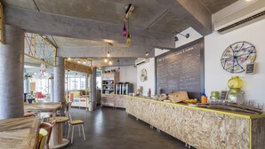 L’intérieur d’un café moderne, avec un comptoir en bois, un espace salon et un menu écrit à la craie.