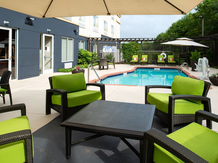 Een buitenzwembad, ligstoelen bij het zwembad