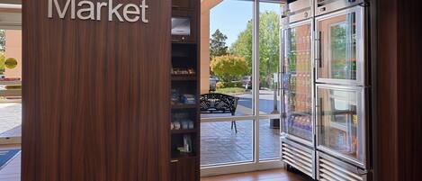 A corner market with a wooden interior, a glass door entrance, and a refrigerator display.