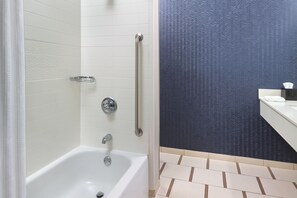 A modern bathroom with a white bathtub, a handrail, and a sink with a towel. - Fairfield Inn & Suites by Marriott Anderson Clemson (Anderson)