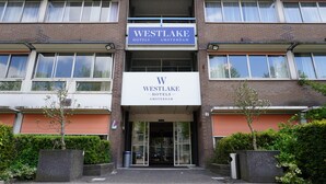 A Westlake Hotels Amsterdam building with a prominent sign, a gated entrance, and a brick facade. - Westlake Hotels Amsterdam (Amsterdam)