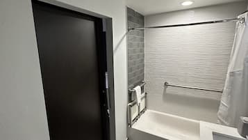 A modern bathroom with a bathtub, a shower, and a toilet.