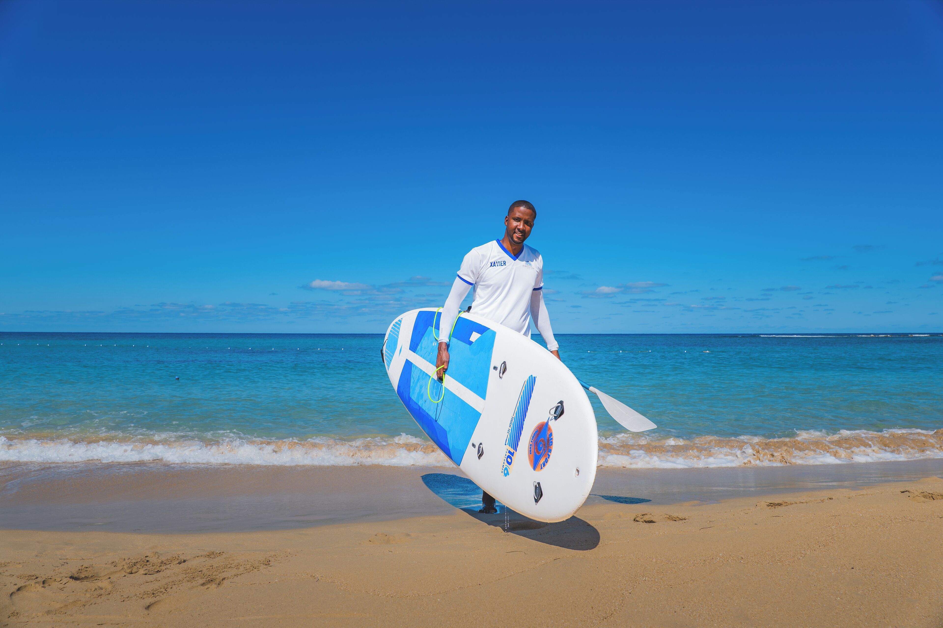 A person holding a surfboard on a beach.