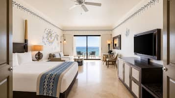 A hotel room with a bed, a desk, a TV, and a balcony with a view.