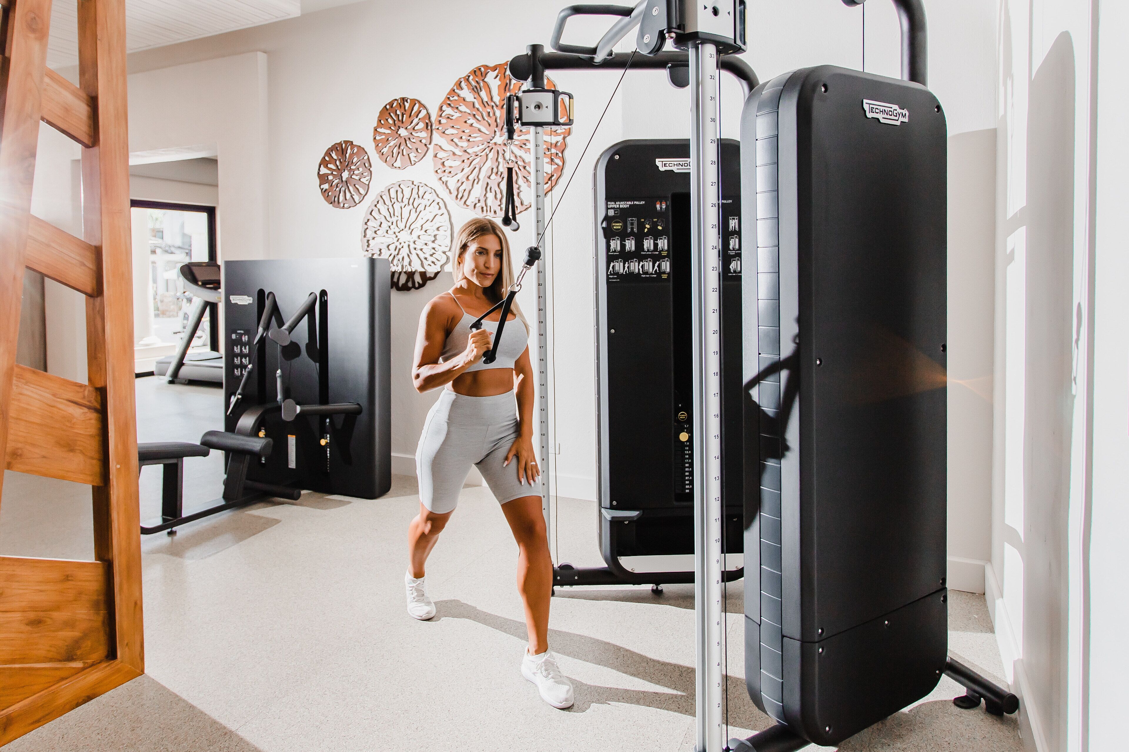 Un gimnasio con equipo de ejercicio, incluyendo una máquina de pesas y una estructura para sentadillas.