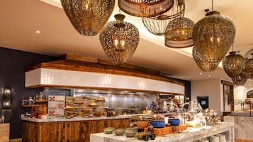 Una cocina moderna con encimera de mármol, detalles de madera e iluminación decorativa colgante.