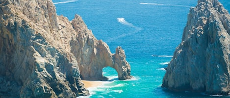 A coastal landscape with rugged cliffs and a natural arch formation.