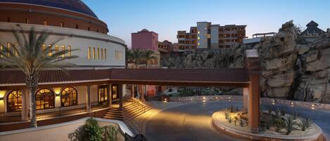 Un hotel con una cúpula grande, un patio con una fuente y un paisaje rocoso.