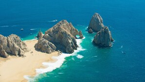 Un paysage côtier caractérisé par des formations rocheuses et une plage de sable.