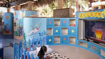 Kids can play and watch their favorite shows in this nautical-themed play area with a large shark on the wall and a TV screen.