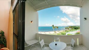 A balcony with a view of the beach and ocean, white chairs, and a small table. - Club St. Croix Beach & Tennis Resort by Antilles Resorts (Christiansted)
