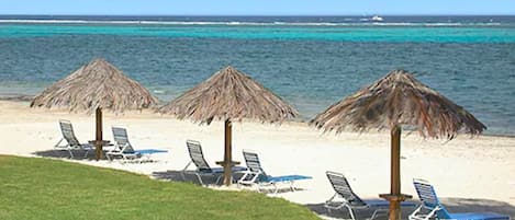 A la platja, gandules de platja i para-sols per a la platja