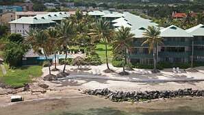A resort with multiple buildings, a pool, and palm trees.