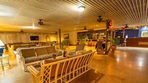 A spacious lobby with a reception desk, seating area with sofas and chairs, and potted plants. - Starfish Tobago Resort (Plymouth)