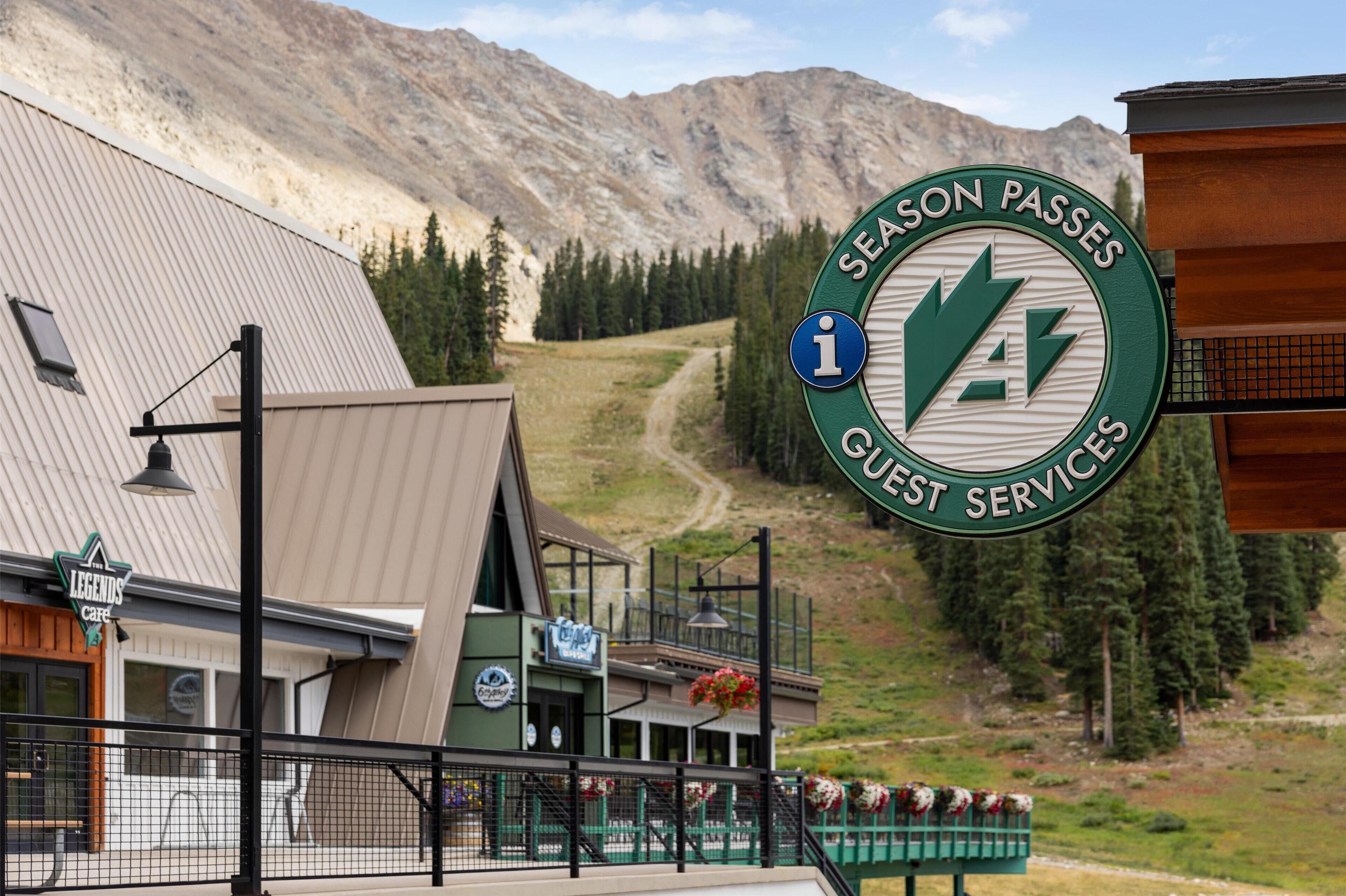 A building with a sign for 'Season Passes Guest Services' and a 'Legends Cafe' sign.